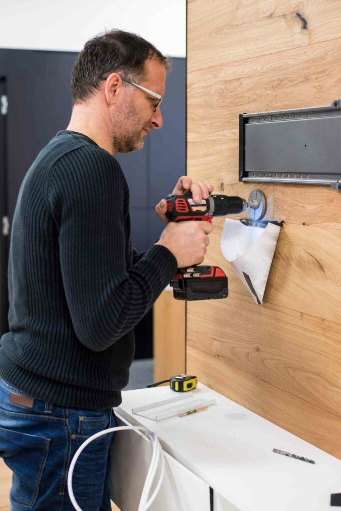 handyman installing TV on. the wall