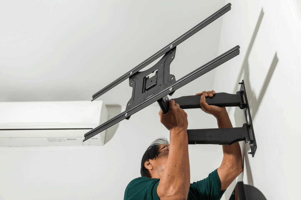 man installing full motion mount